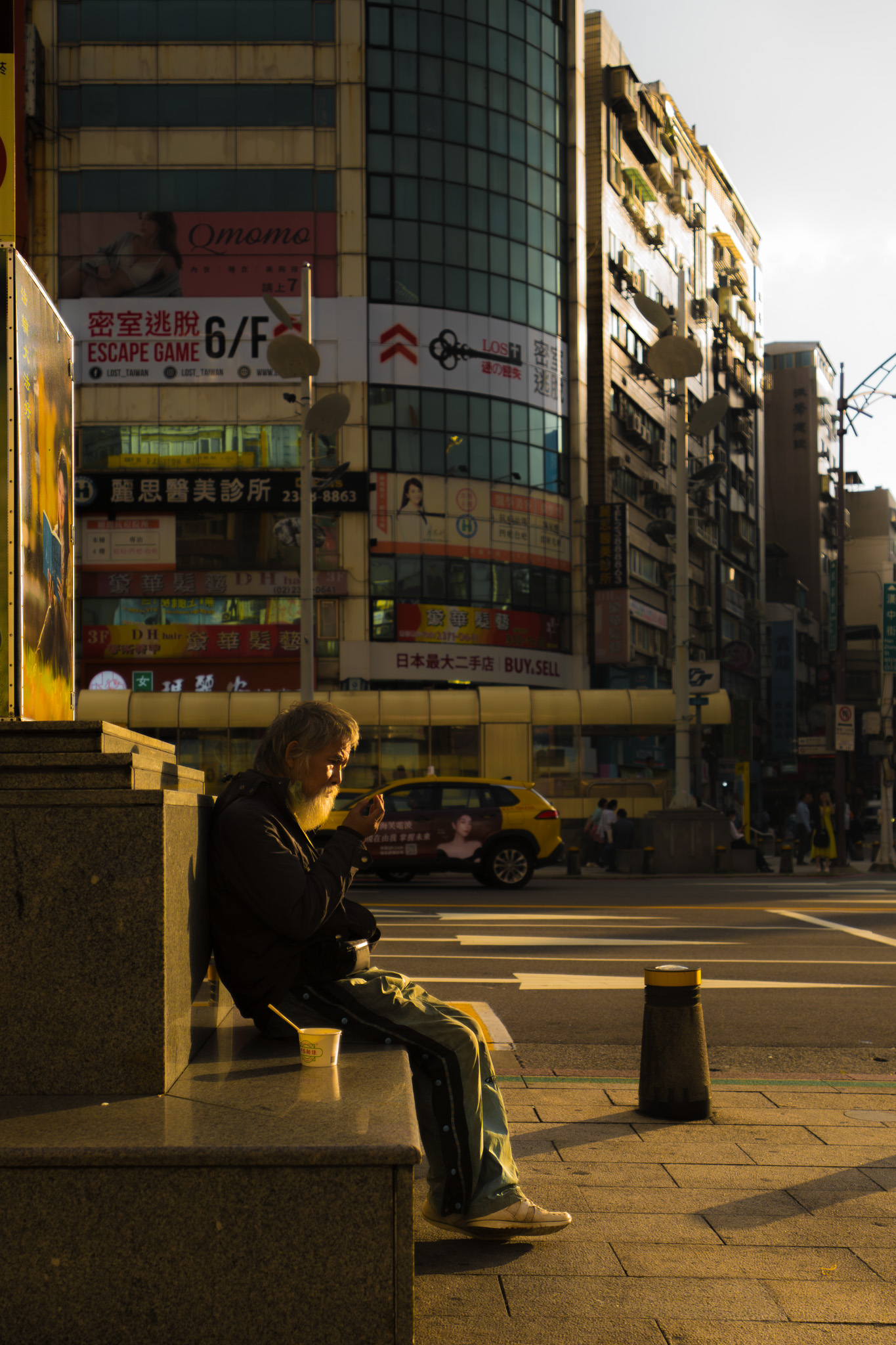 Older man sitting on a city bench in golden light